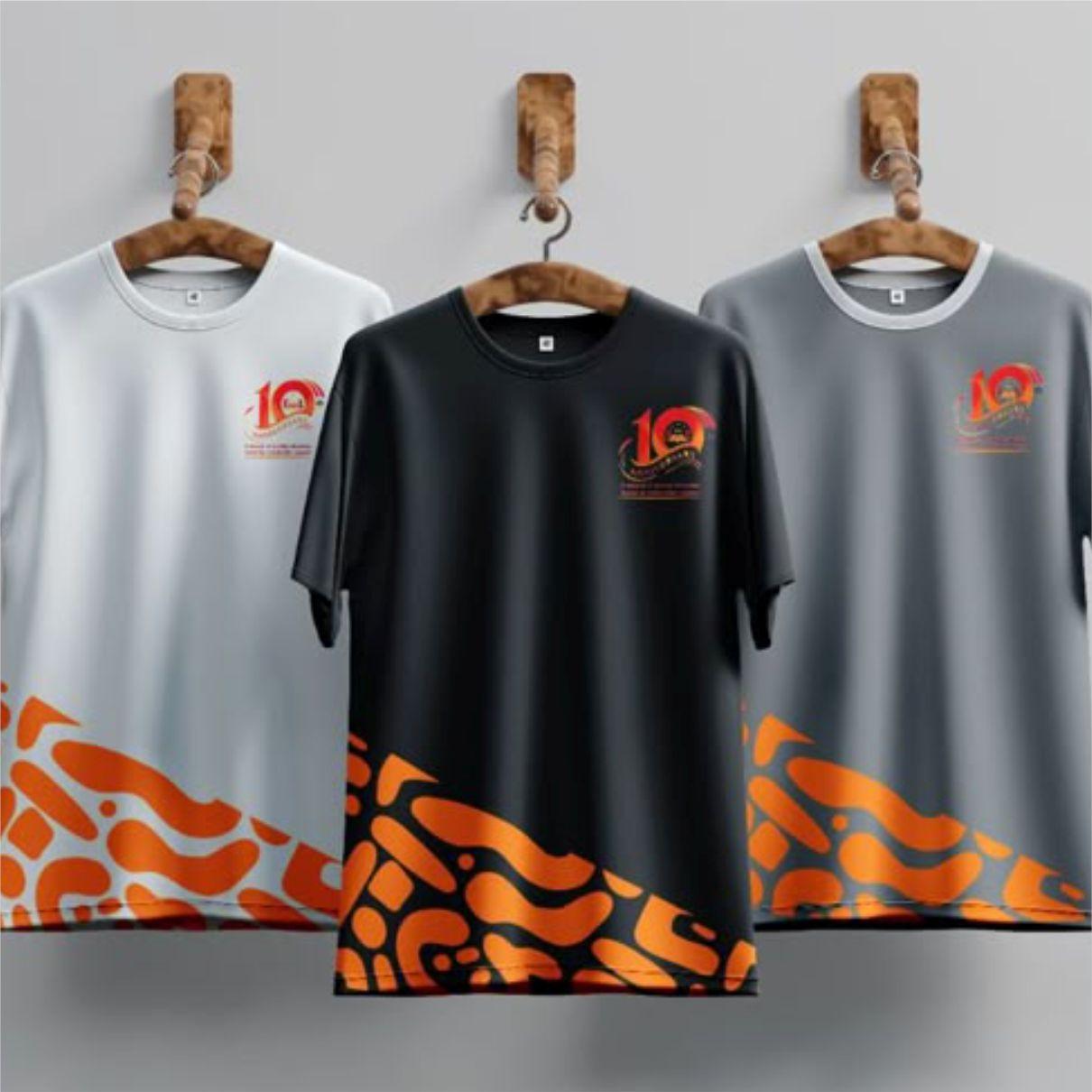 Custom branded event t-shirts displayed on wooden hangers, featuring black, white, and gray color options with orange graphic patterns and a commemorative logo design for corporate events, promotions, and marketing campaigns.